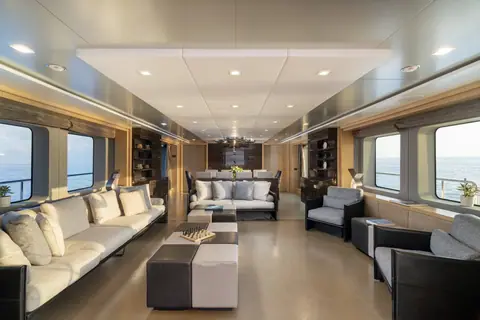 Il salone: i divani chiari, i pouf e le finestre sul mare